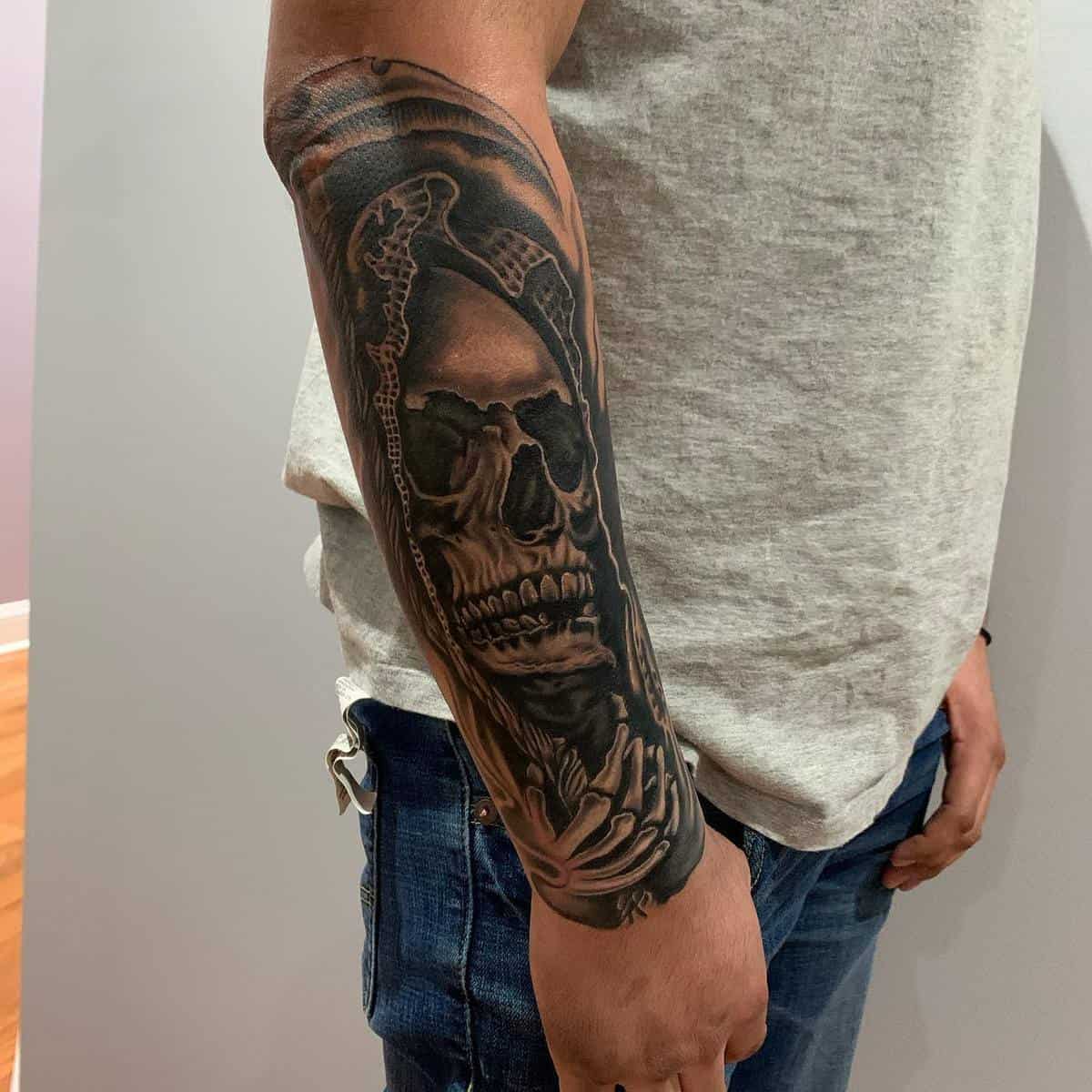 A dark, realistic Santa Muerte tattoo featuring a skeletal figure on the forearm, symbolizing death