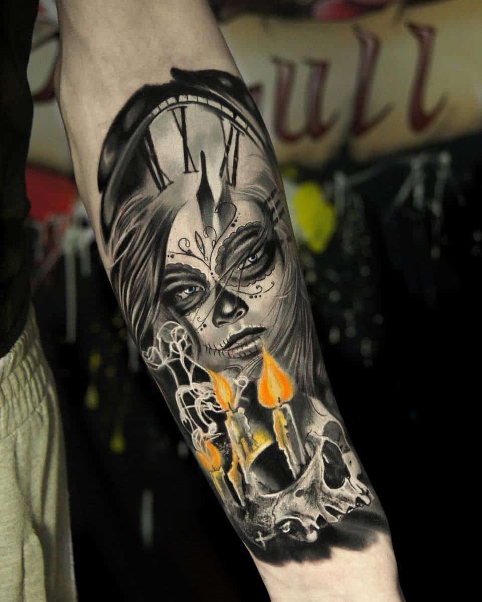 Forearm tattoo featuring a Catrina figure with sugar skull makeup, candles, and a skull, framed by a clock