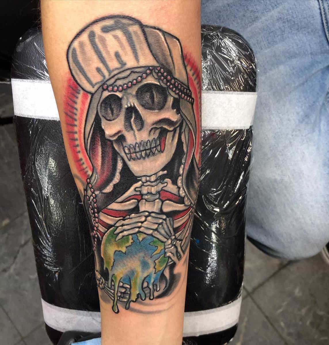 Vibrant Santa Muerte tattoo with a skull, red background, and a melting Earth in her skeletal hands, emphasizing global fragility