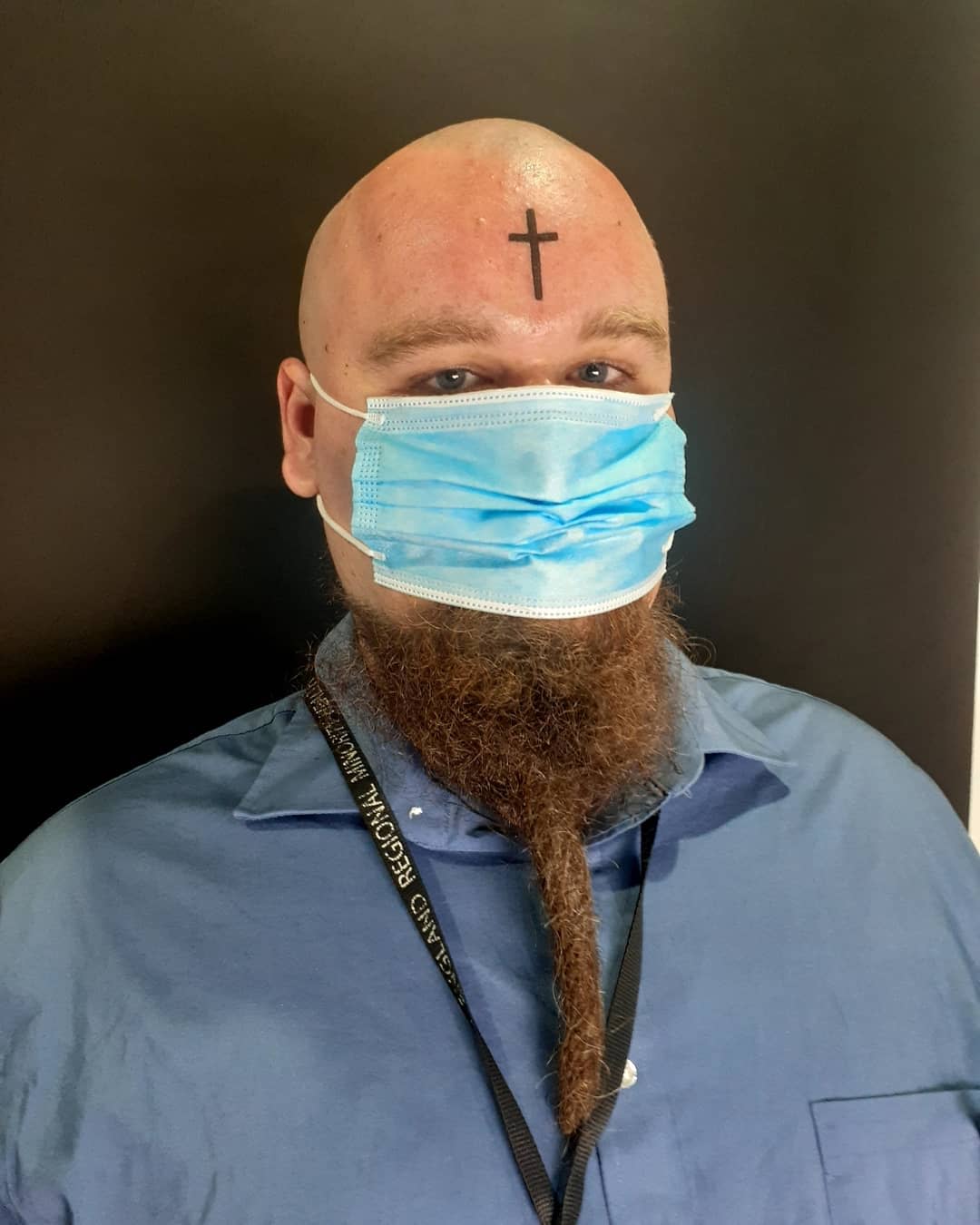 Small cross mark tattoo on forehead