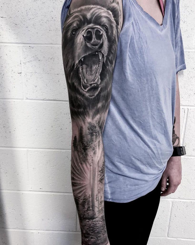 Man with a detailed bear and nature-themed arm tattoo