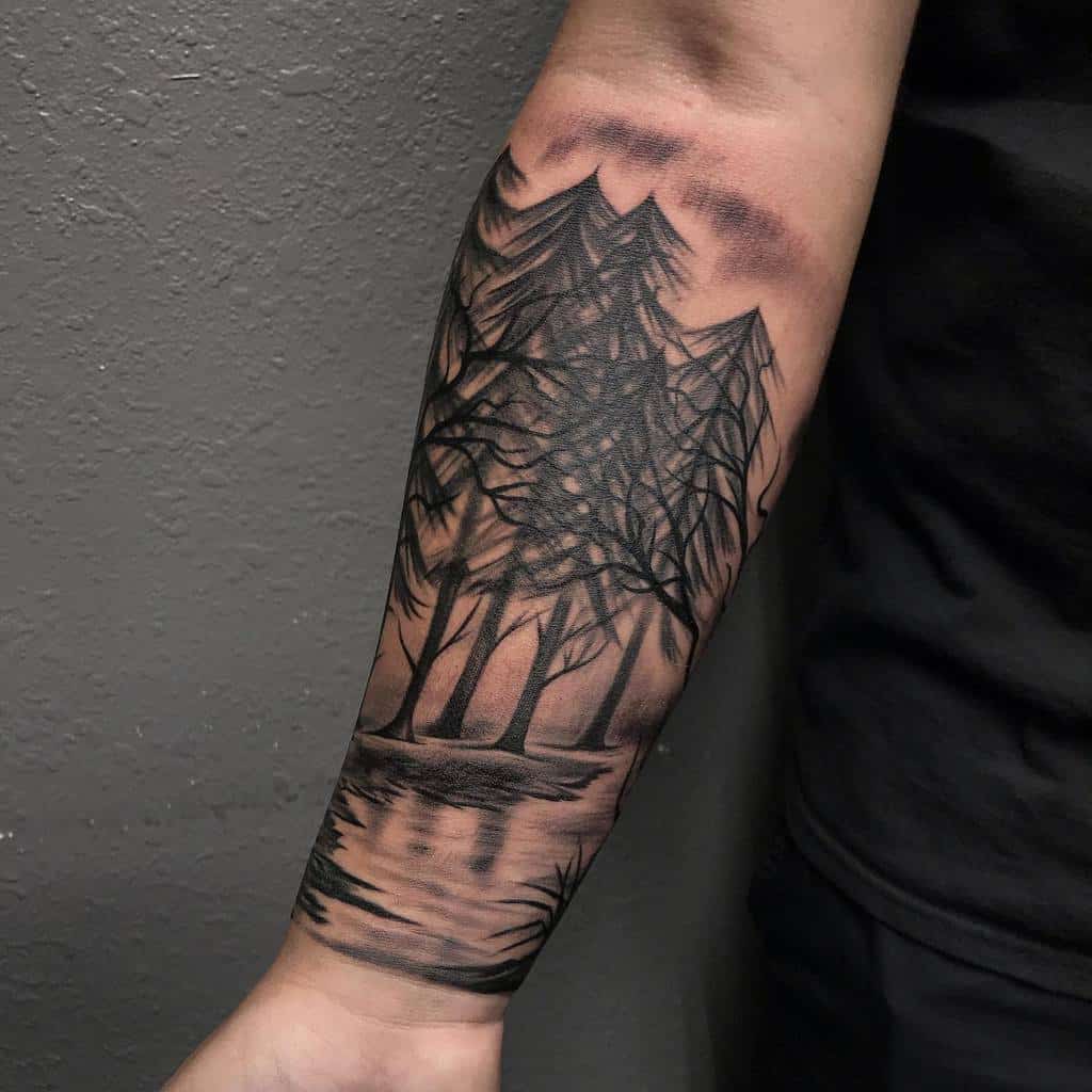 A black ink tattoo featuring a forest scene with tall, detailed trees and their reflection on a calm river, covering the forearm