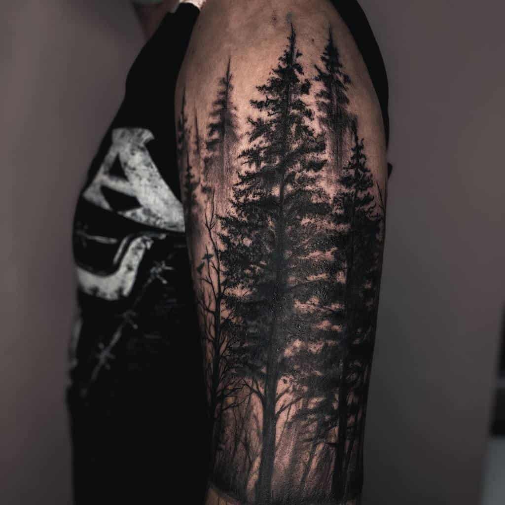 A person's arm showcases a tattoo of tall trees and a forest landscape, expertly inked in silhouette style
