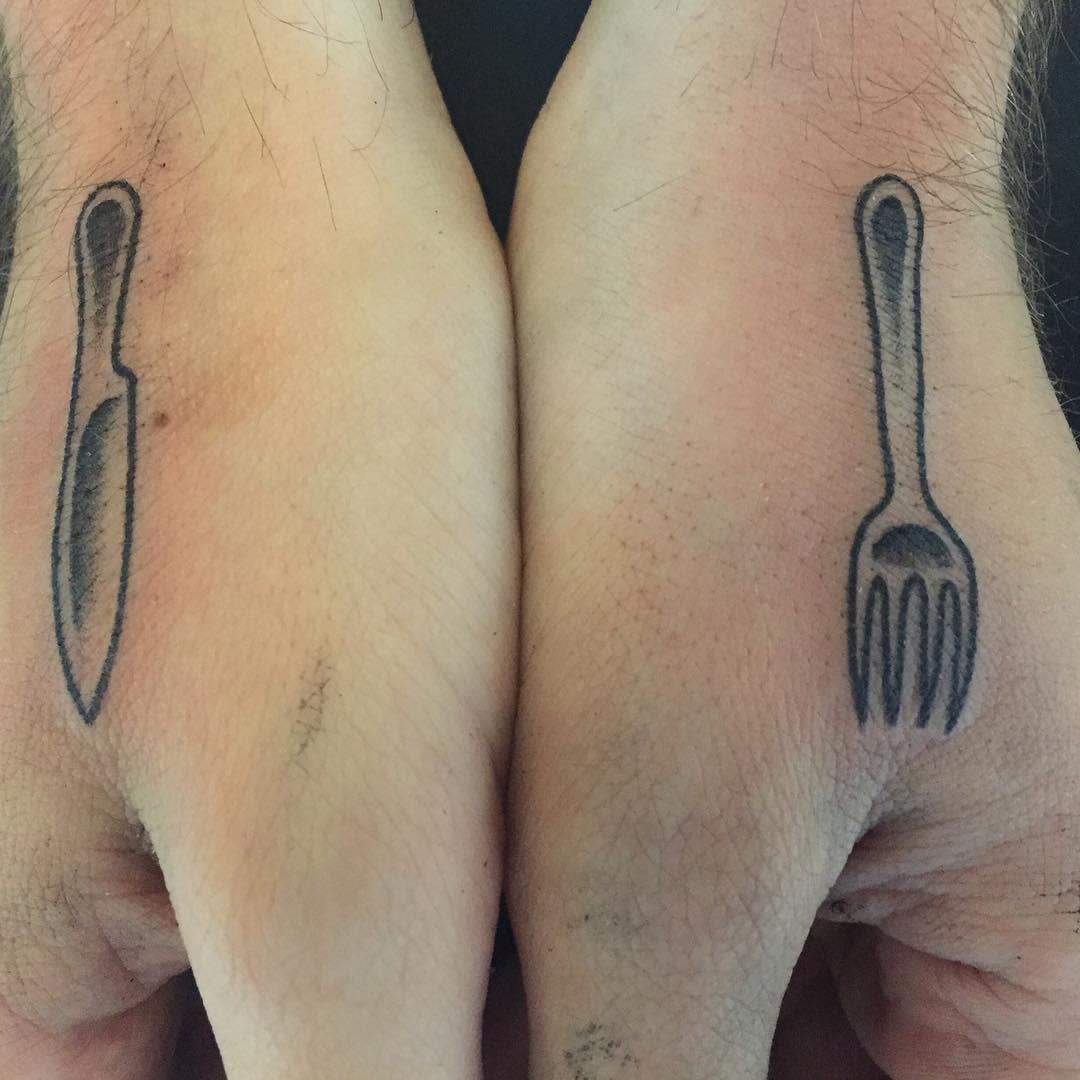 Two hands with a knife tattoo on the left and a fork tattoo on the right