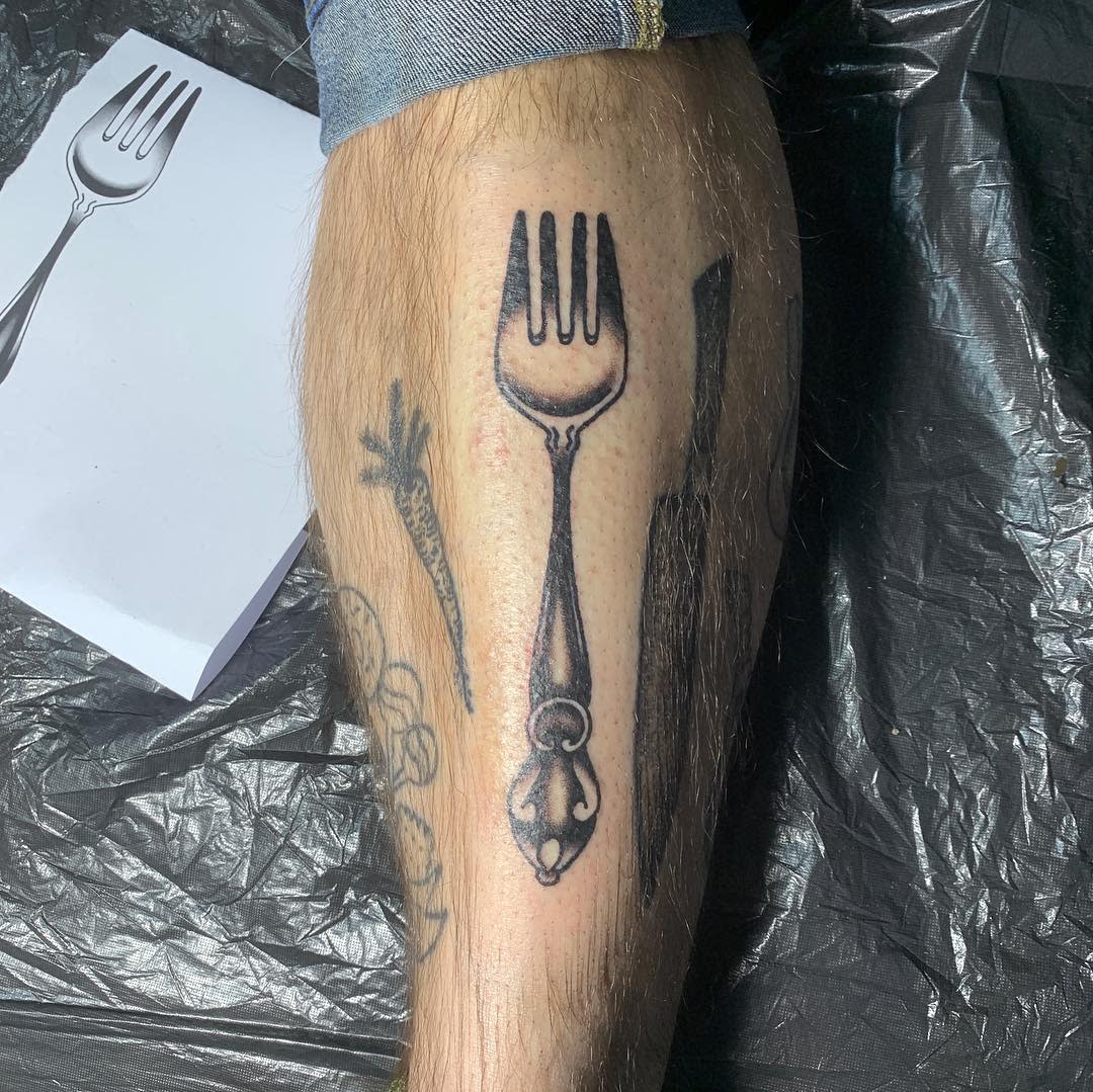 Tattoo of a fork on a leg
