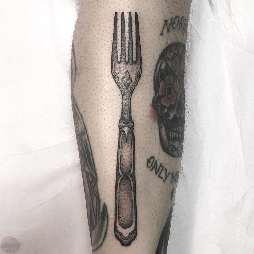 Tattoo of a fork on an arm
