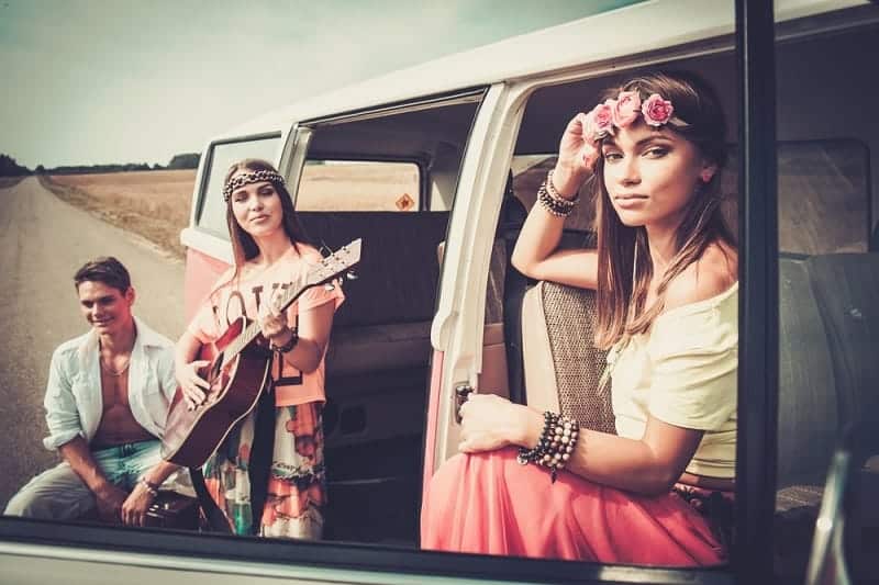 Friends On Roadtrip Dressed In 1970s Hippie Style