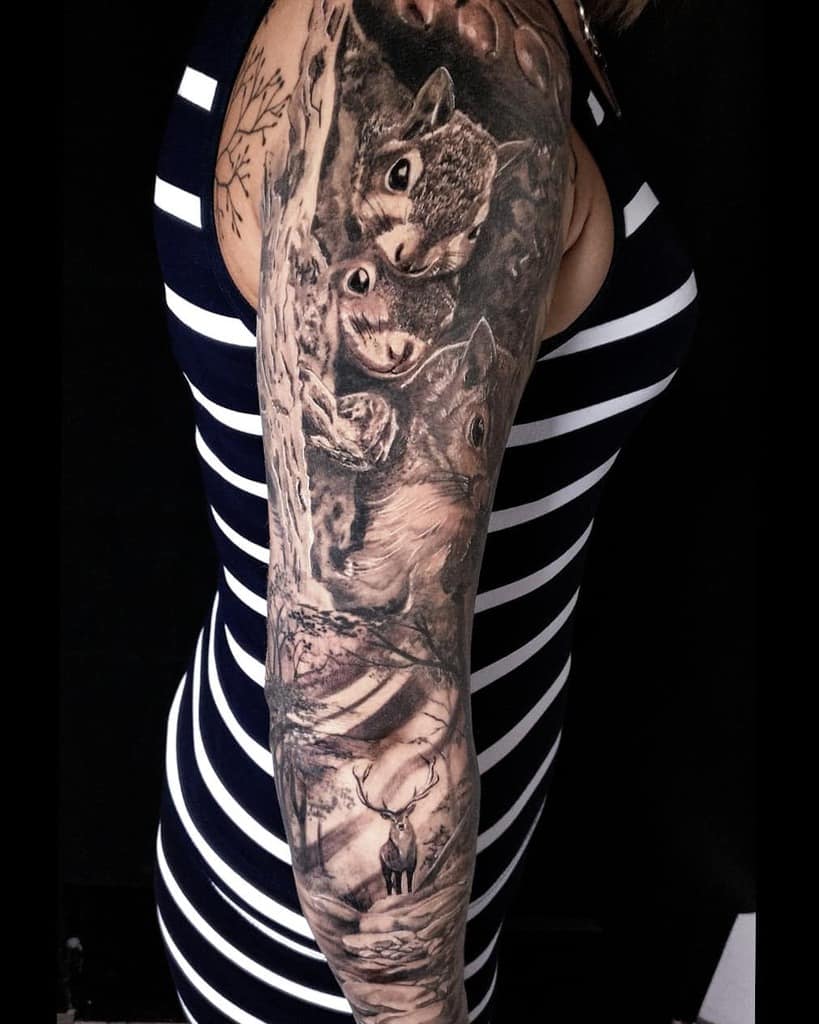 Upper arm tattoo of squirrels and a deer on a person wearing a striped sleeveless top