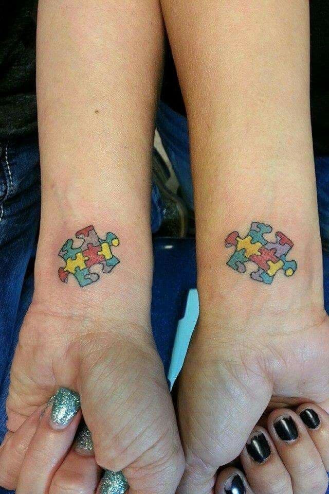 Full color matching wrist tattoo of multi-colored puzzle pieces.