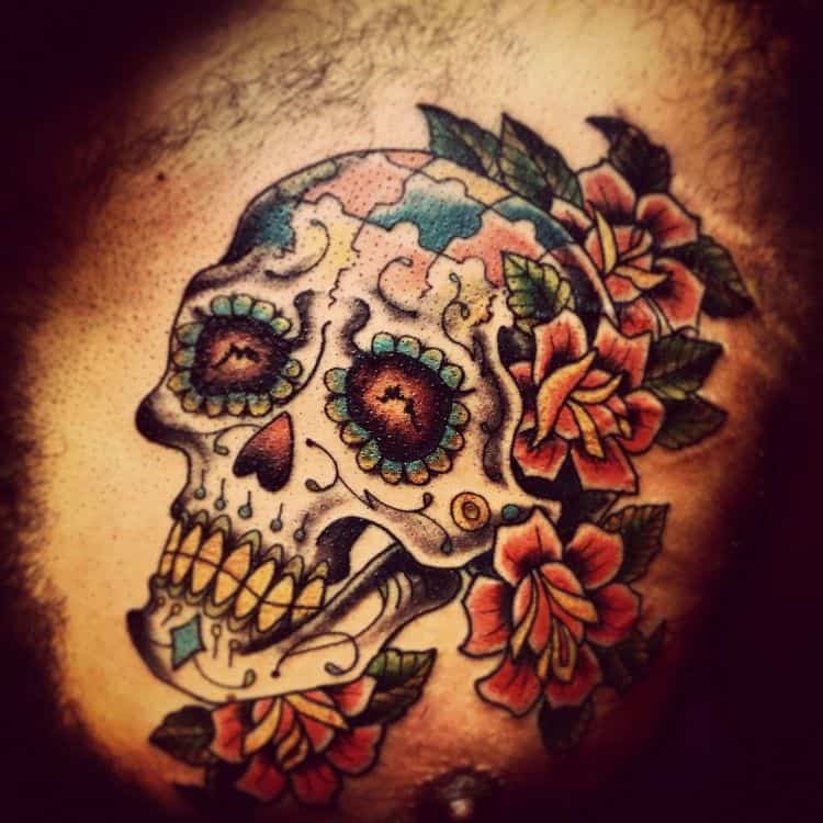 Full color tattoo of Day of Dead skull with multi-colored puzzle pieces and roses.