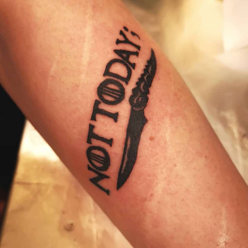 Tattoo of text "NOT TODAY" and semicolon, with knife below it