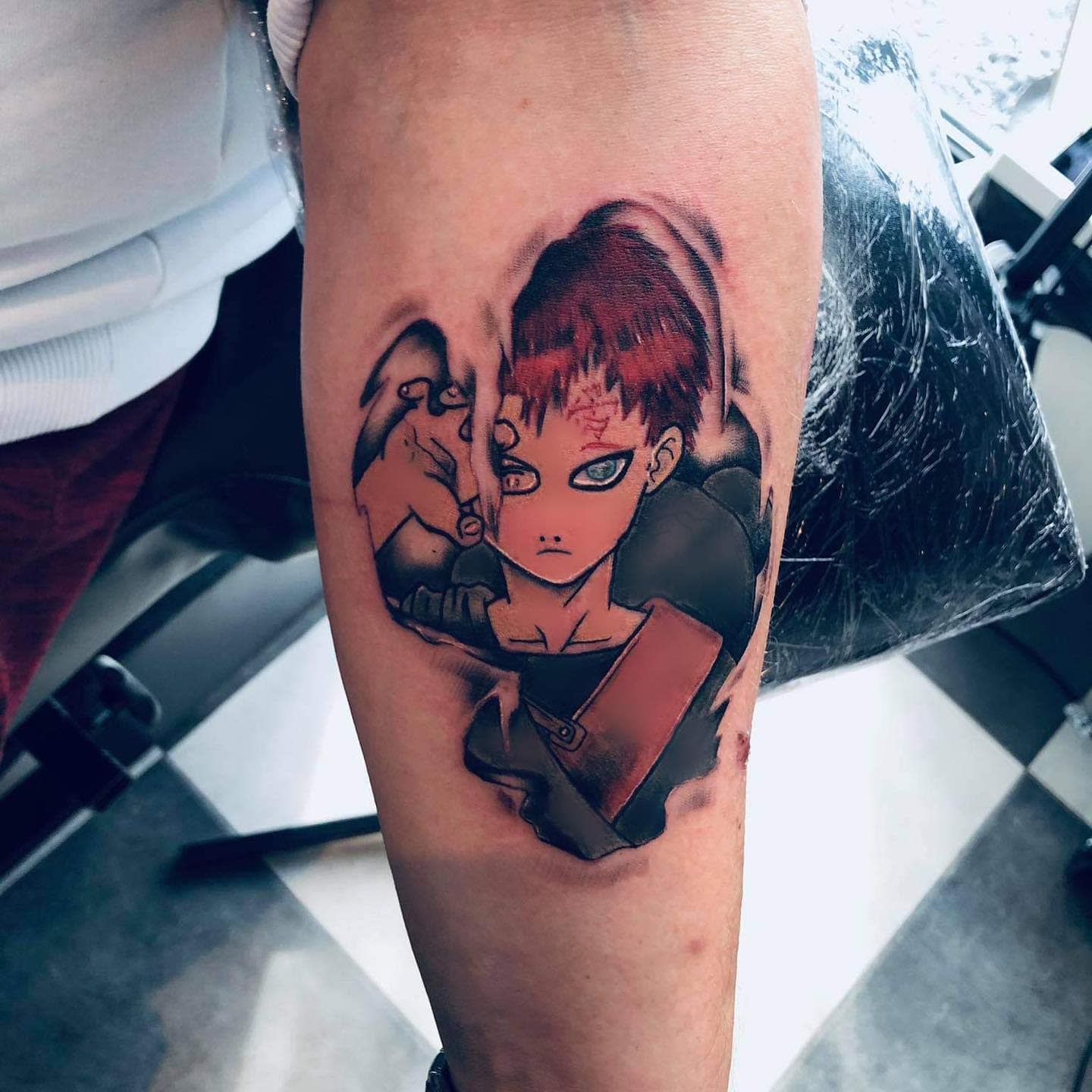 Tattoo of Gaara with red hair and intense expression on a forearm