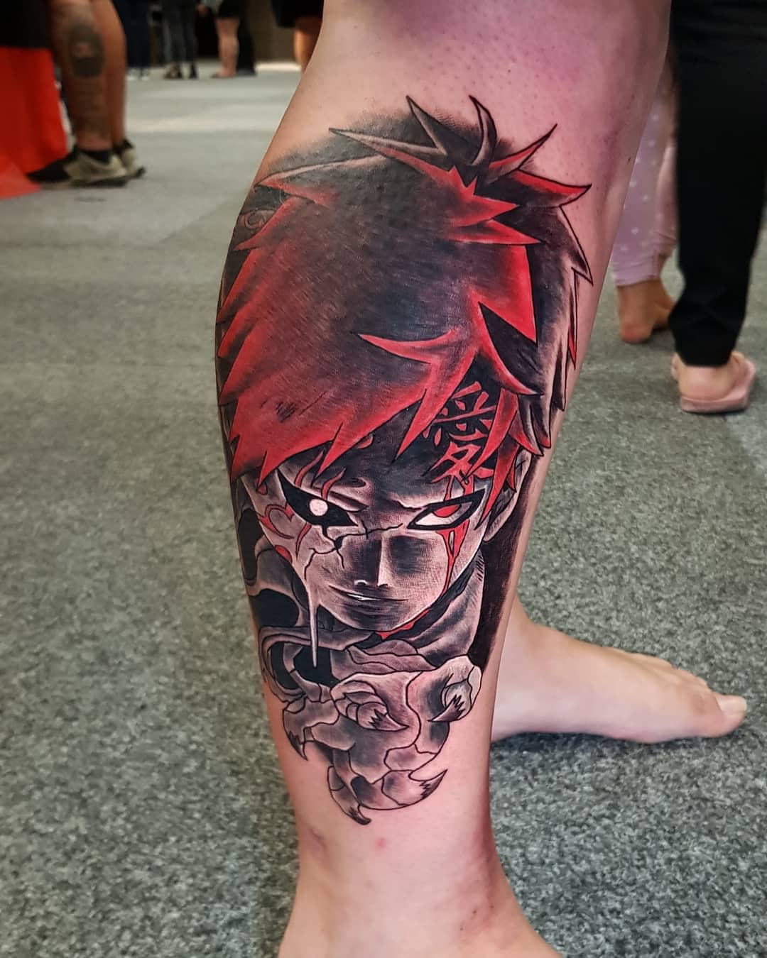 Tattoo of Gaara with red hair and intense eyes on a calf