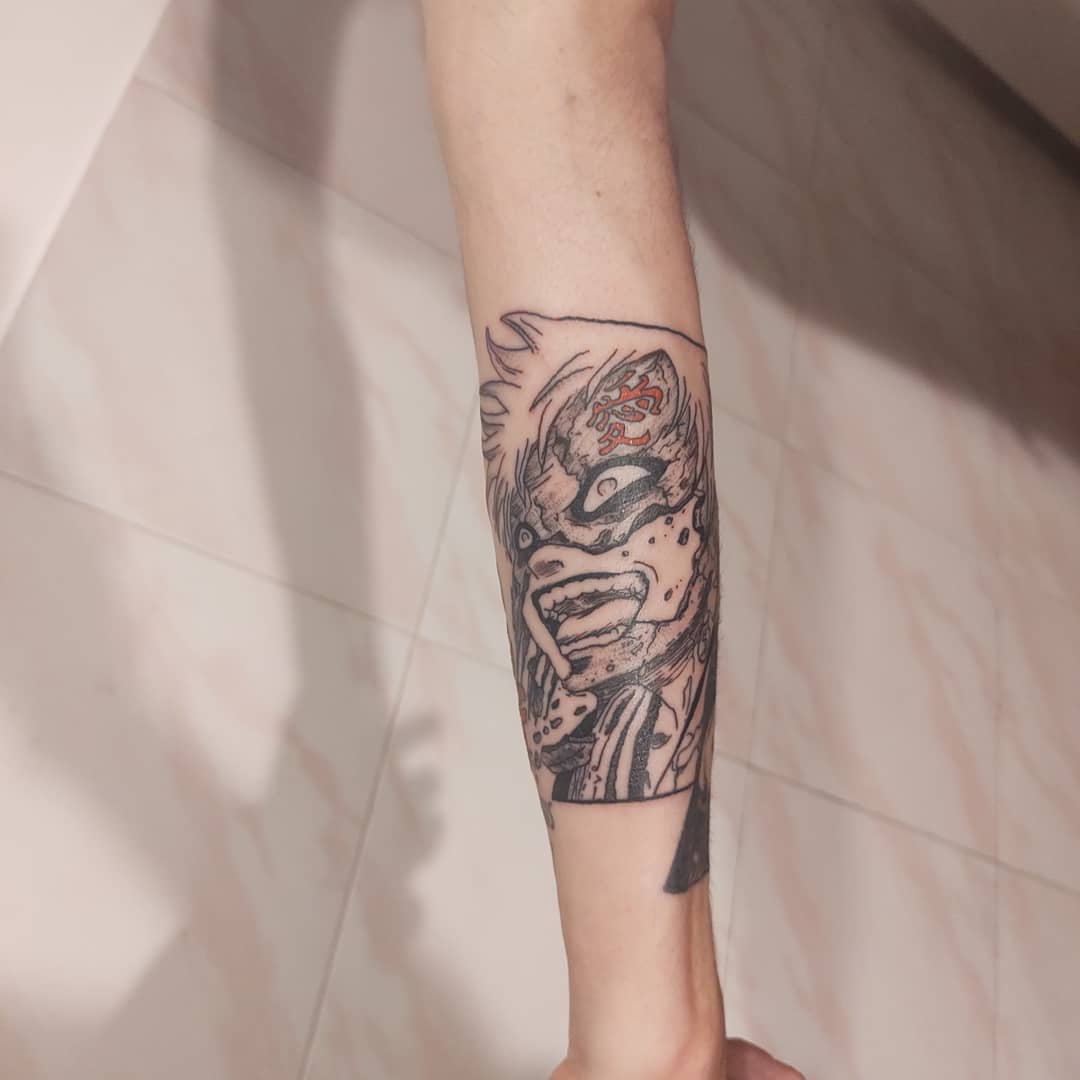 Forearm tattoo with a detailed illustration of an intense, masked character Gaara