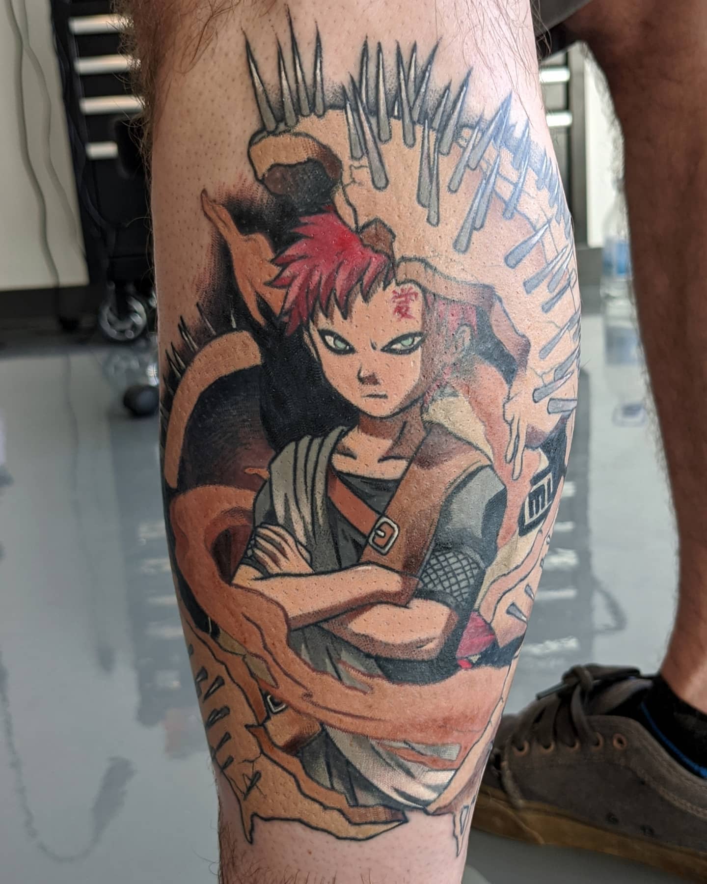 Tattoo of Gaara with red hair and crossed arms on a calf