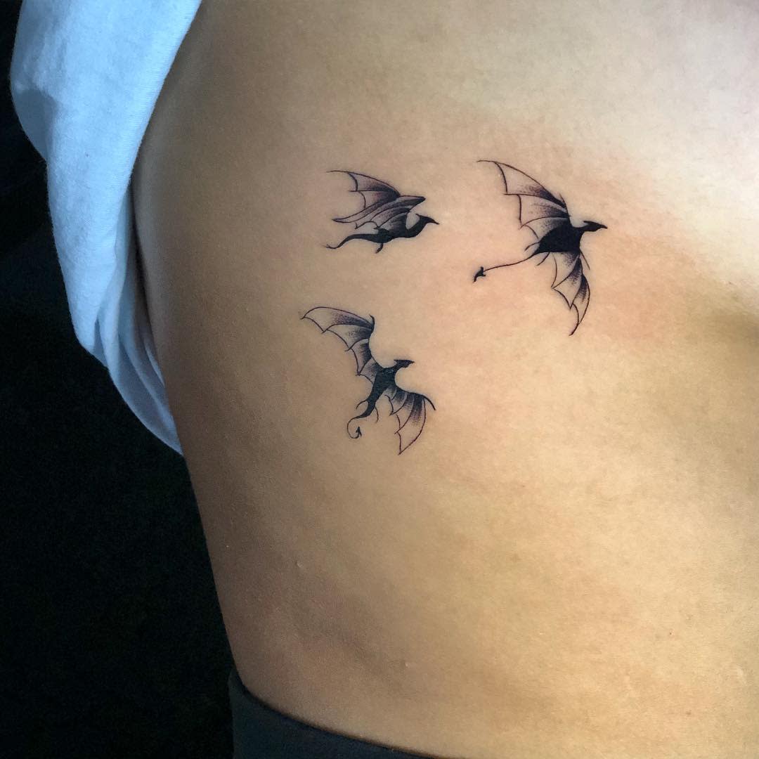 Small tattoo of three flying bats on the side