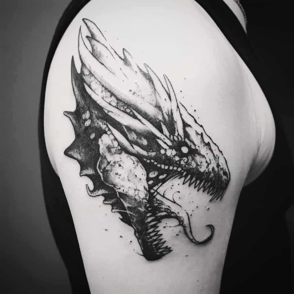 Black and white dragon head tattoo on an arm