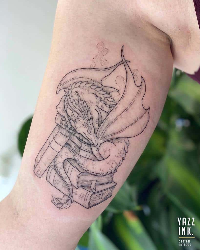 Line art tattoo of a dragon wrapped around stacked books on an arm