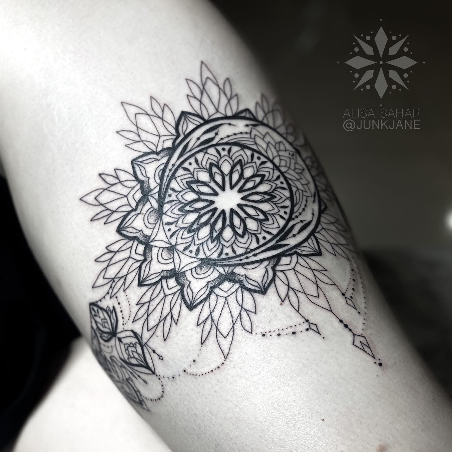 Black ink garter mandala tattoo with intricate geometric and floral designs