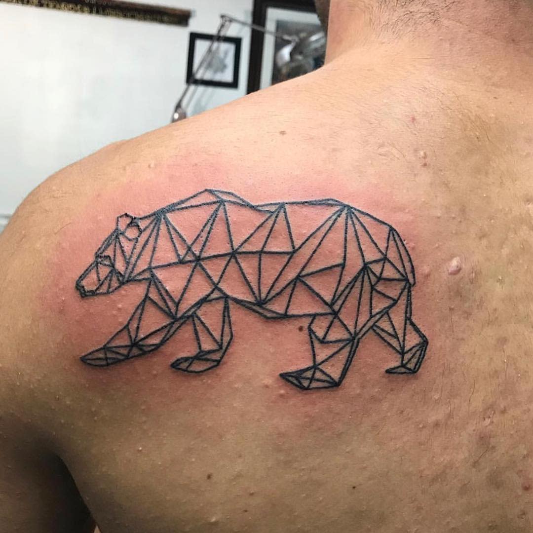 Geometric bear tattoo on a person's upper back with some redness around it, showcasing intricate lines and patterns