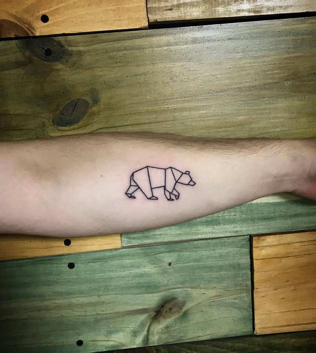 Geometric bear tattoo on a forearm