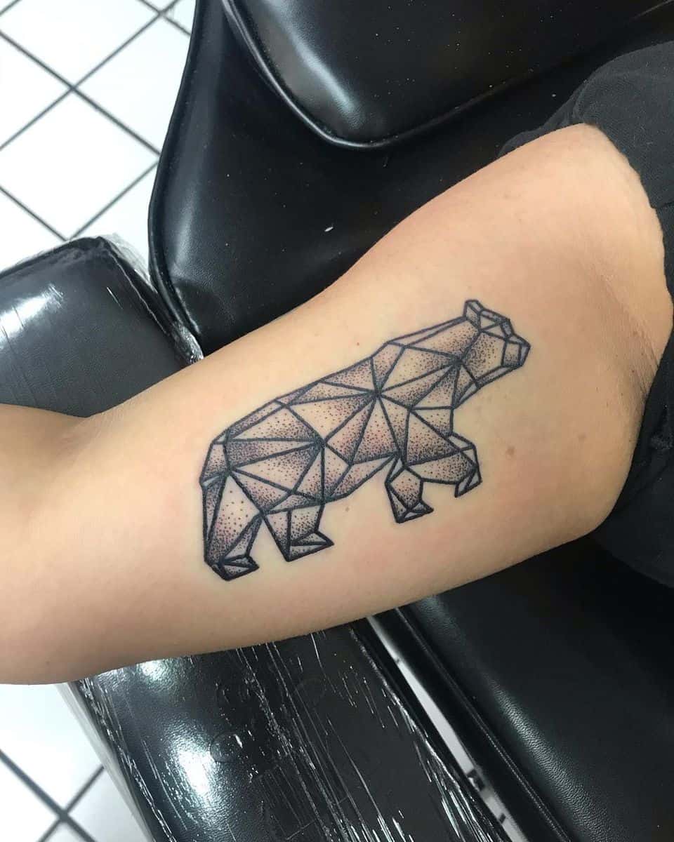 Geometric bear tattoo incorporating dotwork and line art on a person's arm