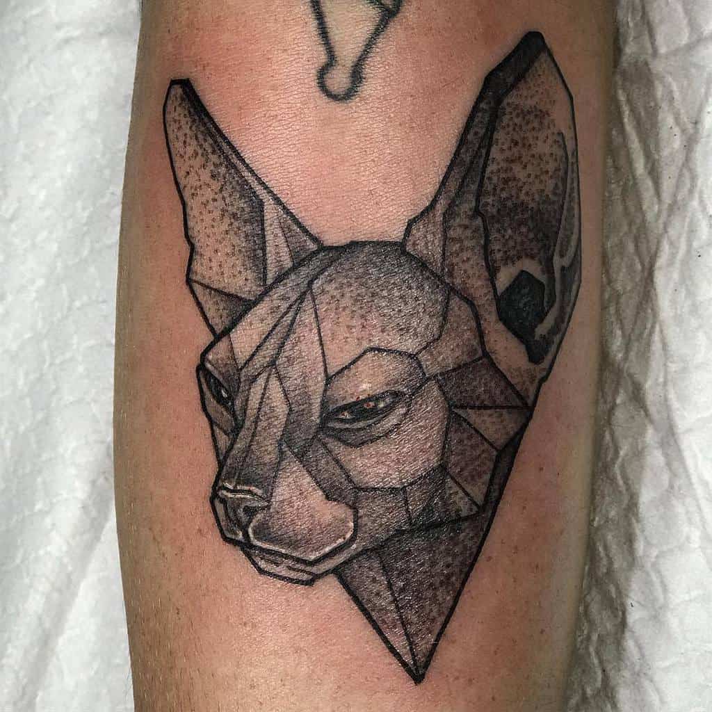 Geometric tattoo of a cat's head with intricate detailing on an arm