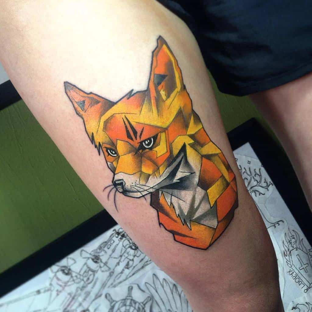 Geometric fox tattoo in vibrant colors artistically inked on a person's thigh