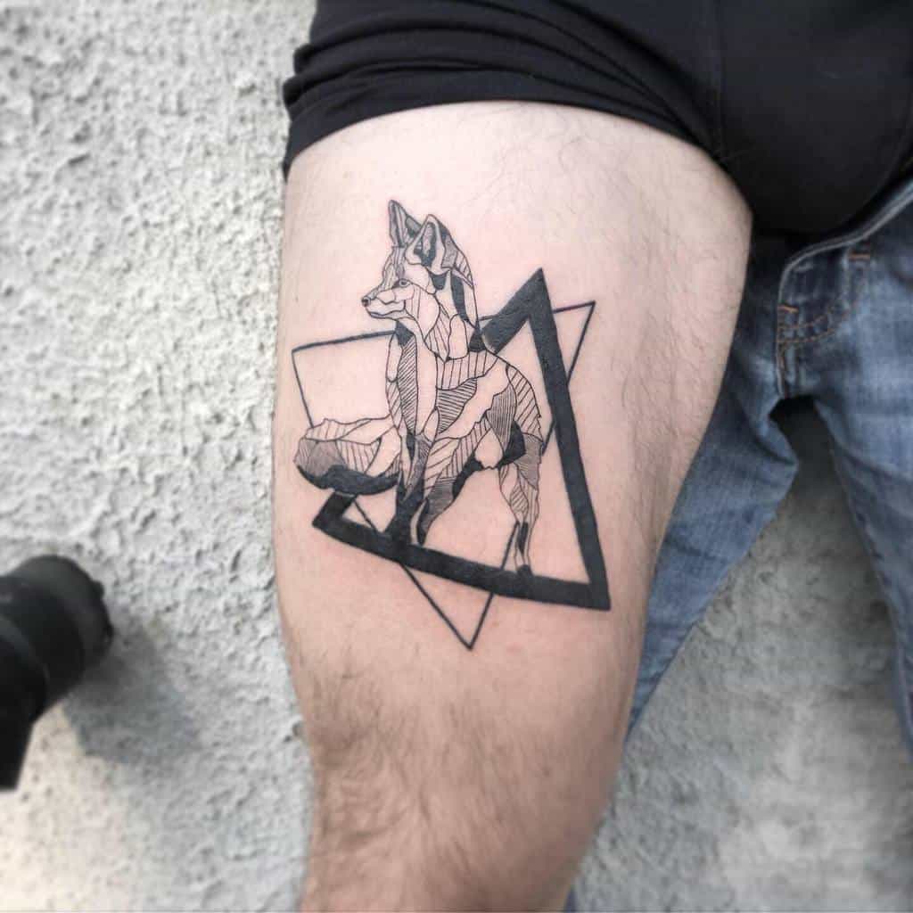 A geometric fox tattoo with a striking triangular background on an upper thigh