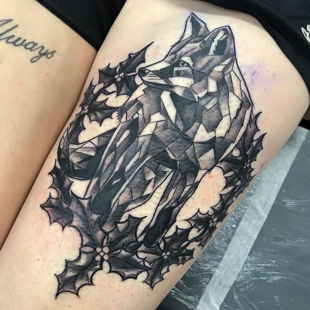 Geometric fox tattoo surrounded by holly leaves on a person's thigh