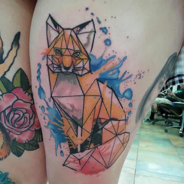 Geometric fox tattoo with colorful watercolor splashes on a thigh