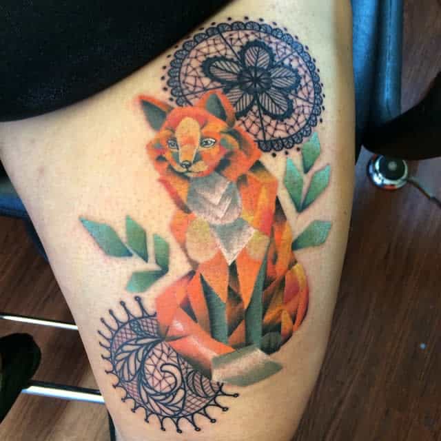 A geometric fox tattoo with intricate mandala designs on the upper thigh