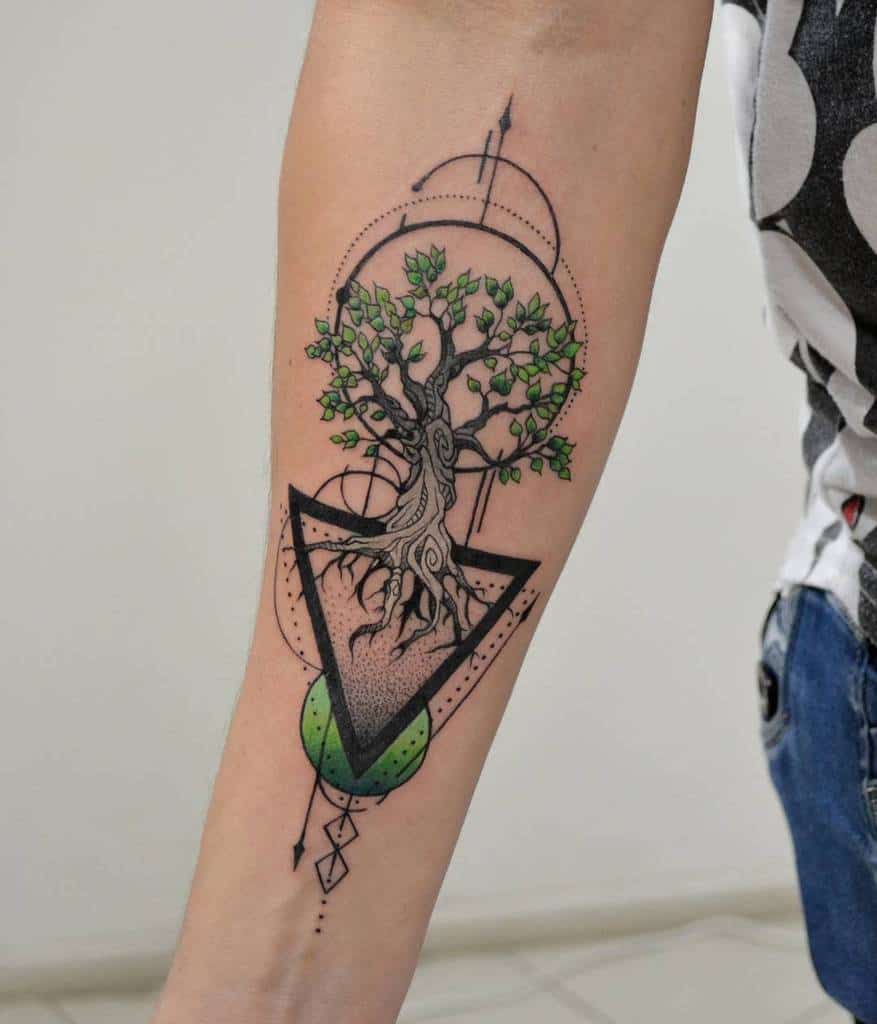 A geometric forearm tattoo featuring a tree with green leaves inside a triangle, with intricate lines and shapes surrounding it