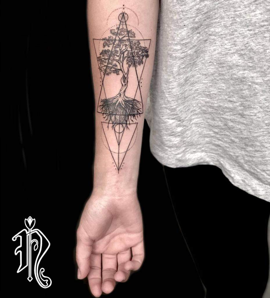 Intricate black ink forearm tattoo of a detailed tree enclosed within geometric triangles, symbolizing balance, growth, and the connection between nature and structure.