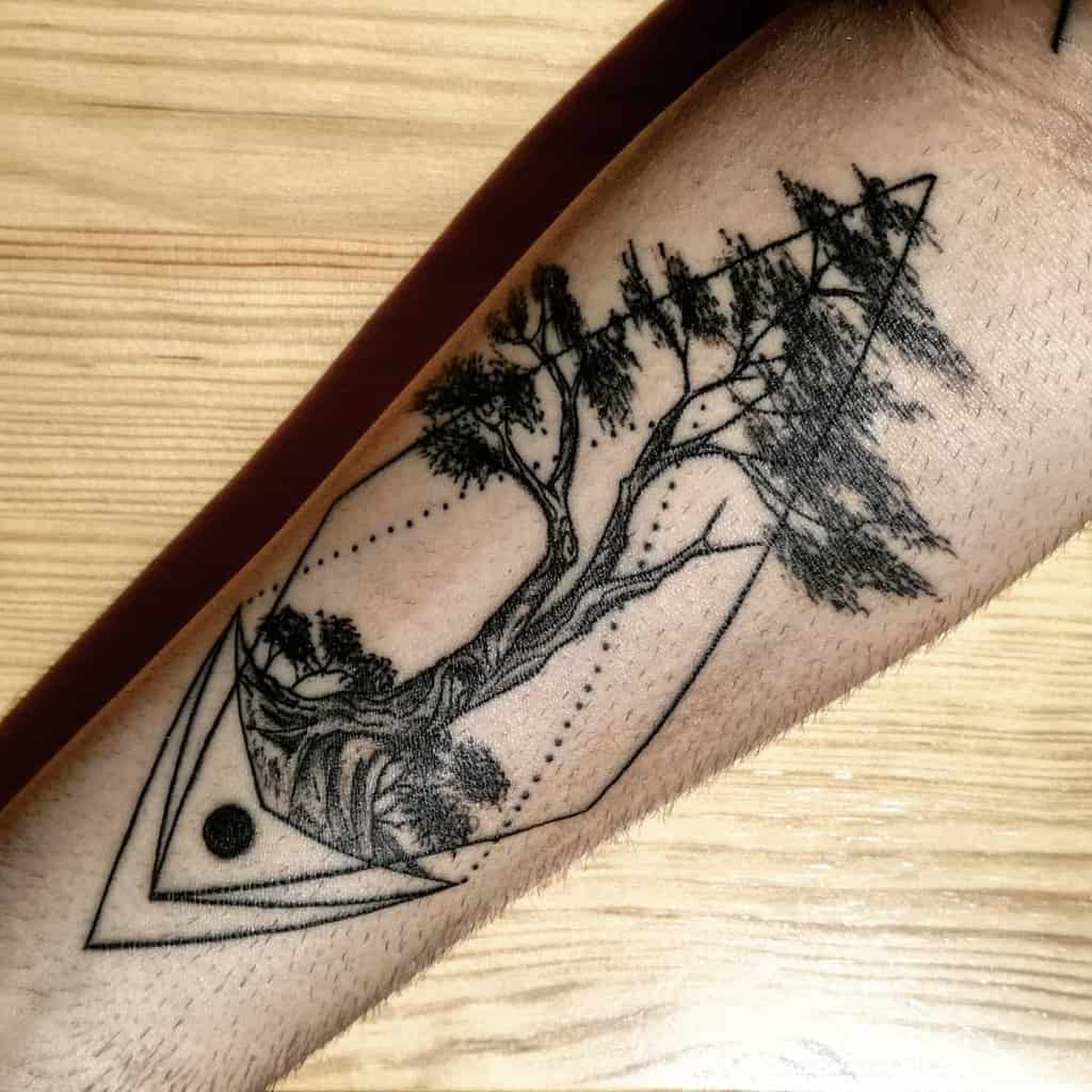 Tattoo on an arm featuring a tree enclosed within geometric shapes
