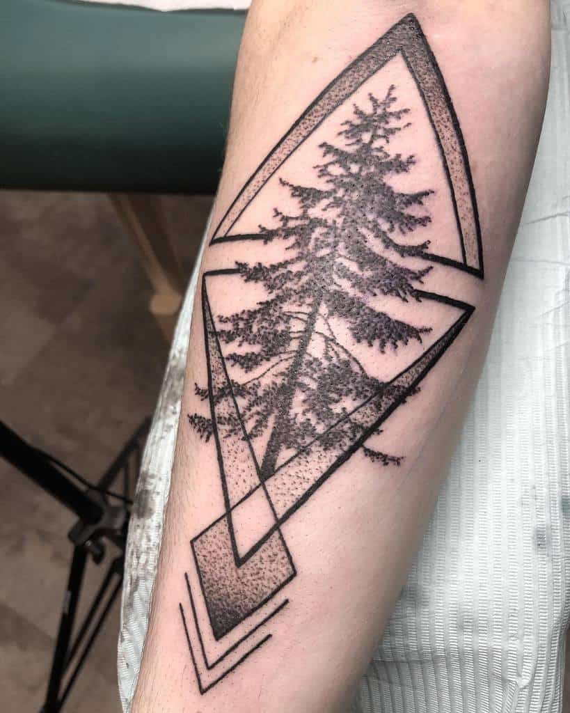 Geometric tattoo design of a tall tree silhouette within overlapping diamond and triangle shapes on a forearm