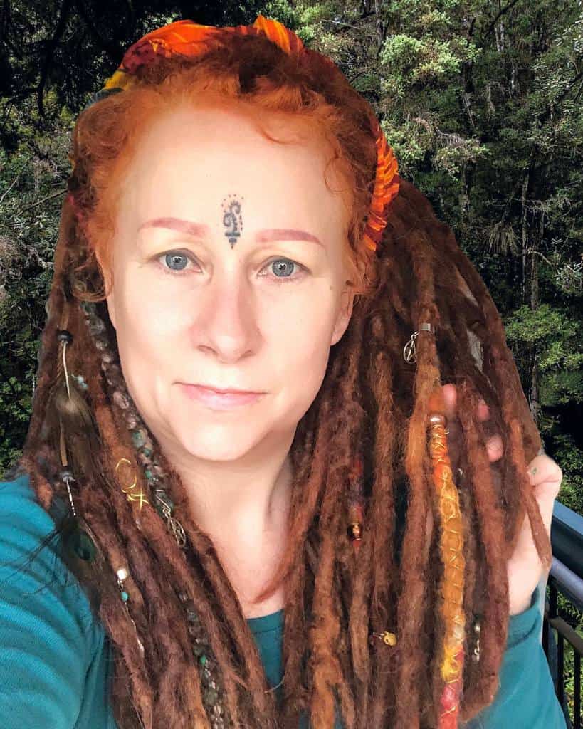 Small decorative tribal tattoo on forehead, featuring a simple swirling design