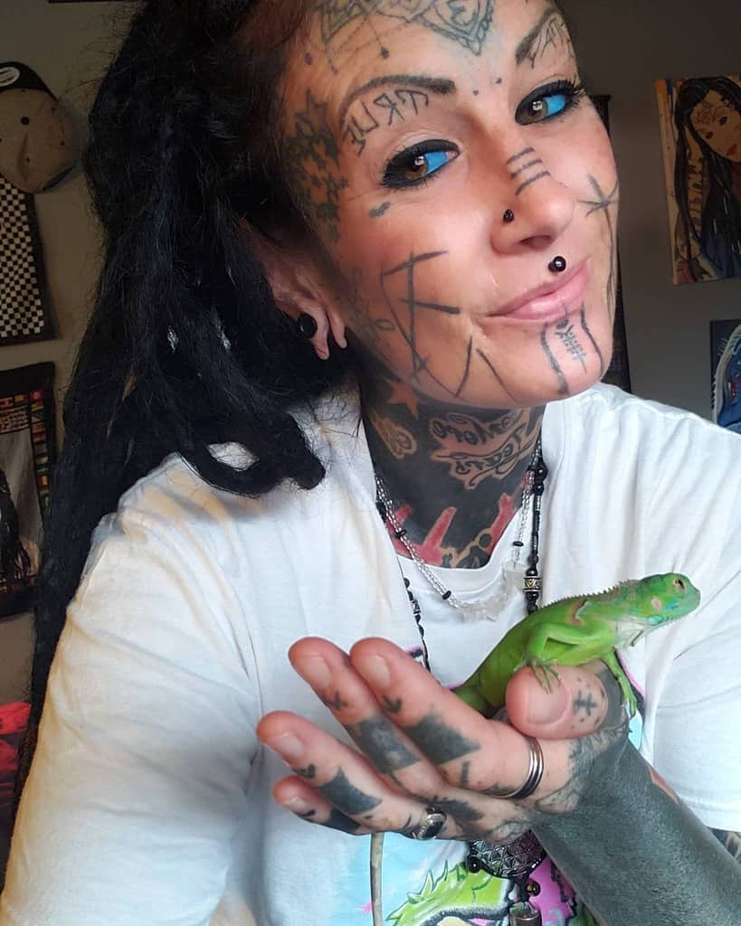 A woman with extensive tribal-style facial tattoos