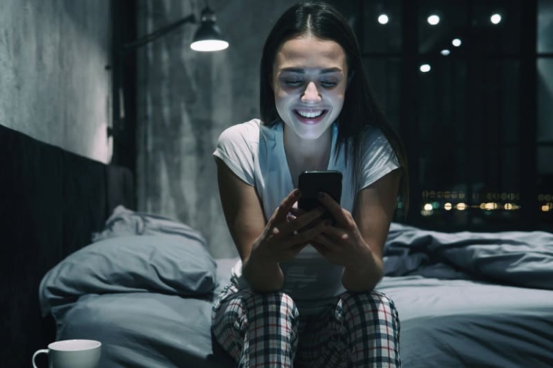 Girl Smiling Looking At Phone