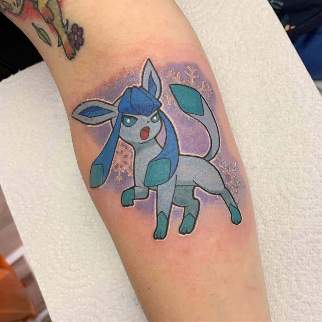 Vibrant Glaceon tattoo with icy blue tones, snowflake details, and a glowing purple background for a frosty effect