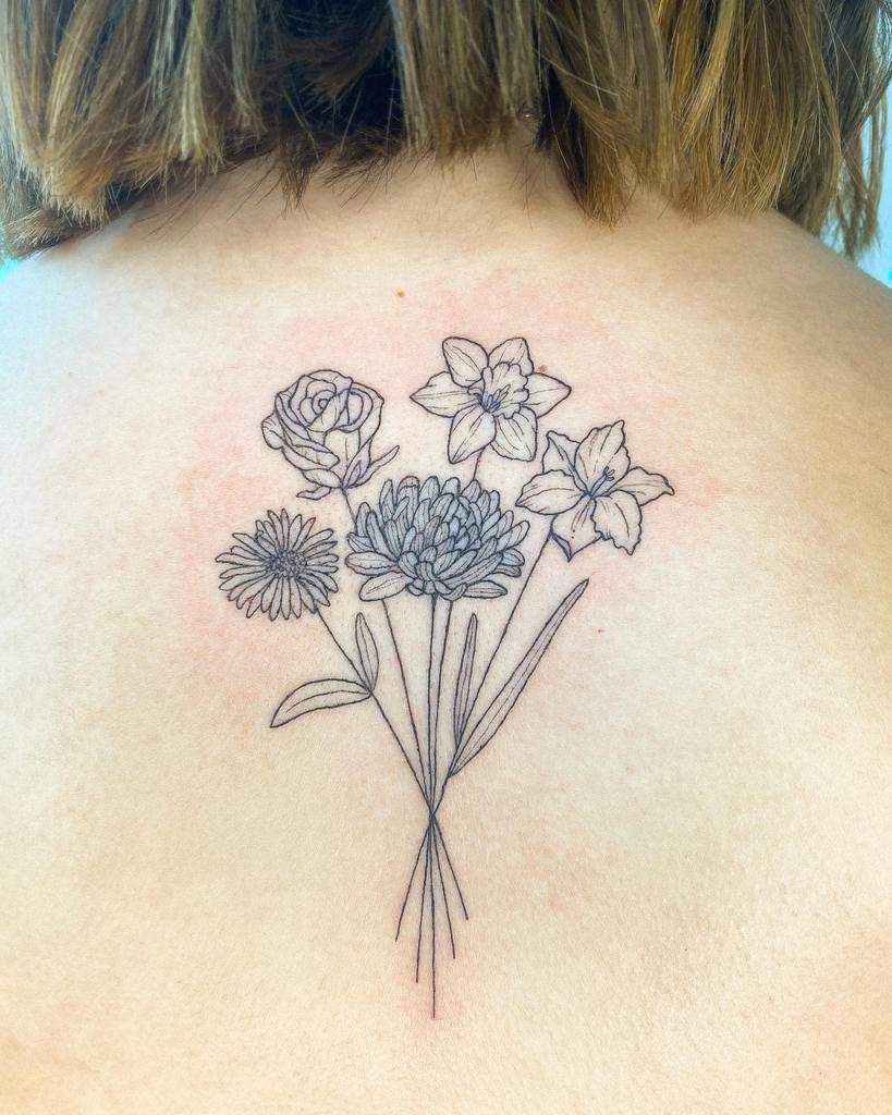 Sure, here's a description for you: A black line tattoo of gladiolus flowers on a person's upper back