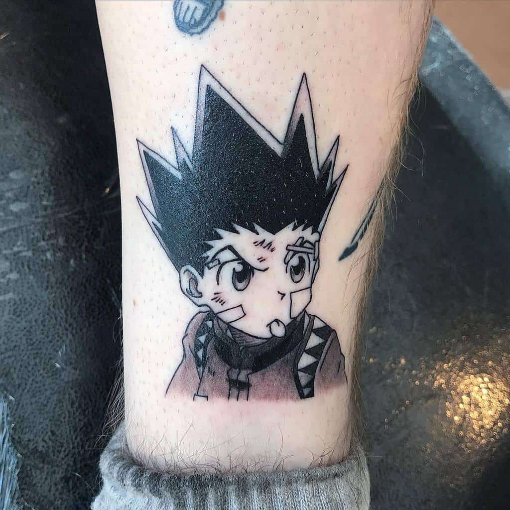 Detailed tattoo of Gon Freecss from Hunter x Hunter, featuring his determined expression with bandages and bold linework on the leg