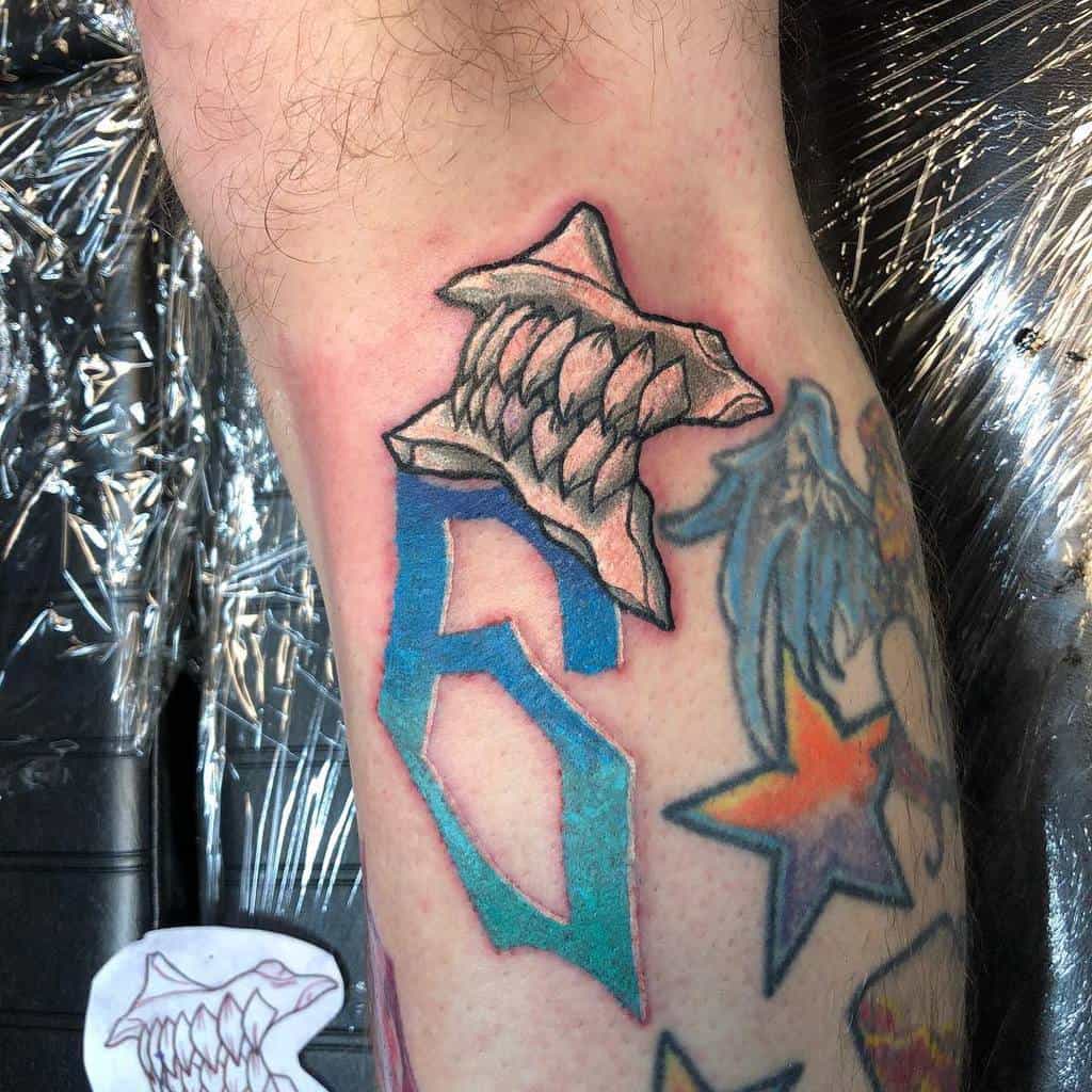 Colorful tattoo of Grimmjow Jaegerjaquez’s Hollow mask fragment and the number 6, representing his Espada rank, from Bleach