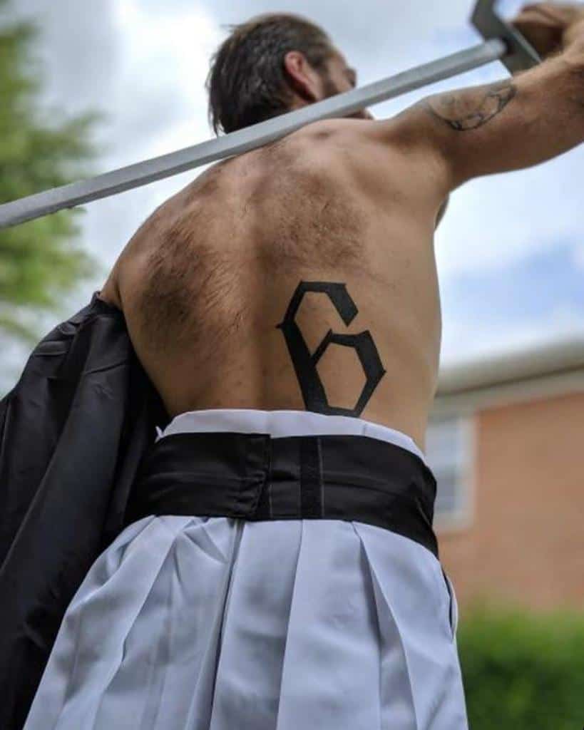 Black tattoo of the number 6, inspired by Grimmjow Jaegerjaquez’s Espada rank from Bleach