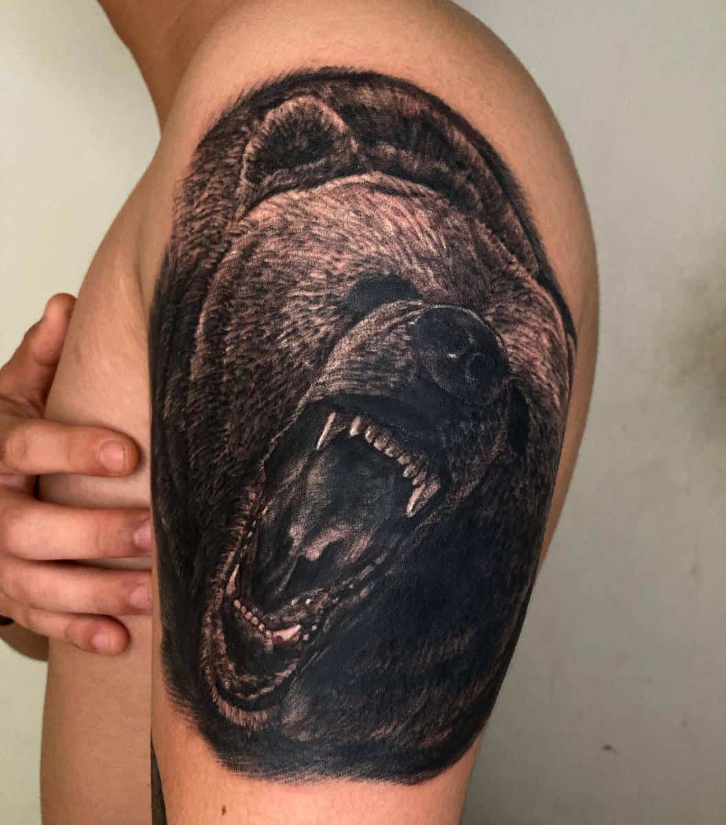 Tattoo of a majestic bear roaring on a person's upper arm