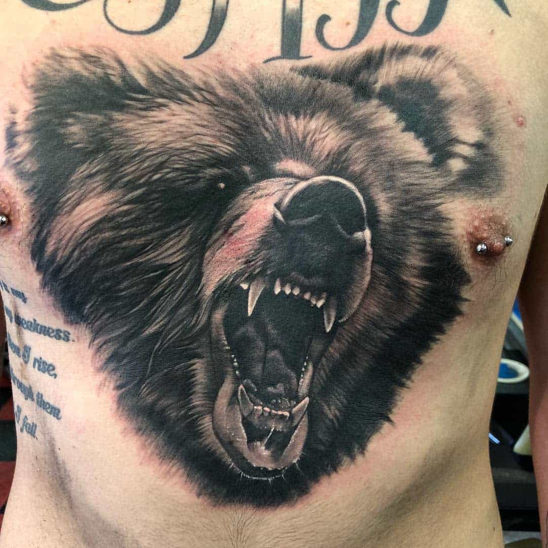 Tattoo of a roaring bear's head on a chest