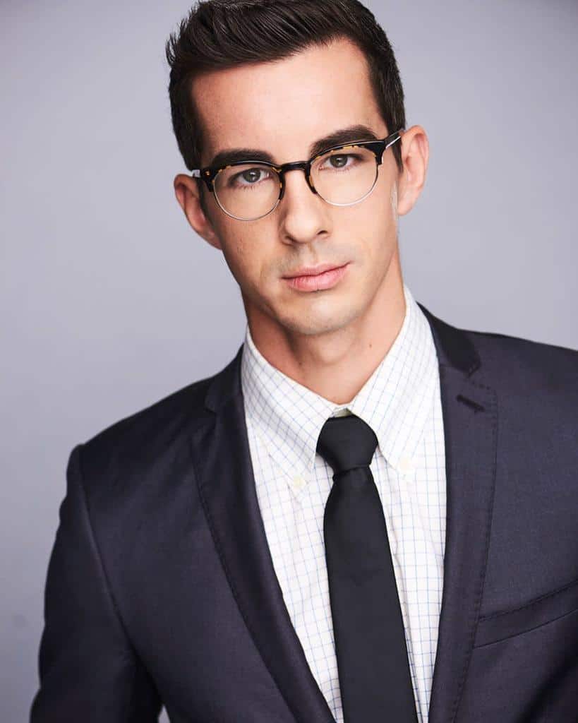 Guy In Smart Suit And Tie Wearing Glasses