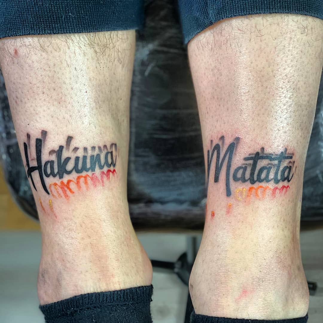 The tattoo on the photo features the phrase "Hakuna Matata" in a playful and vibrant design, highlighting elements of color and creativity