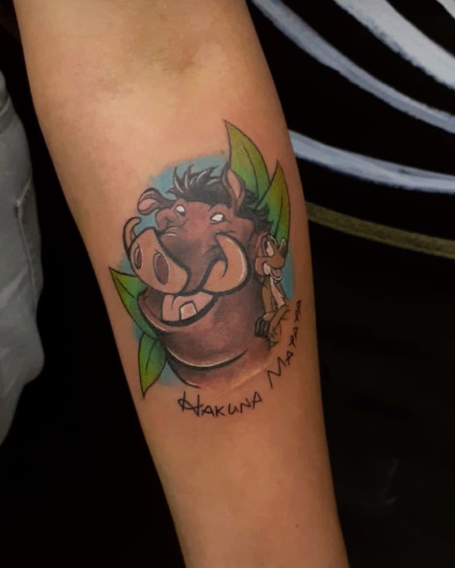 Tattoo of Pumbaa and Timon from "Hakuna Matata" on an arm