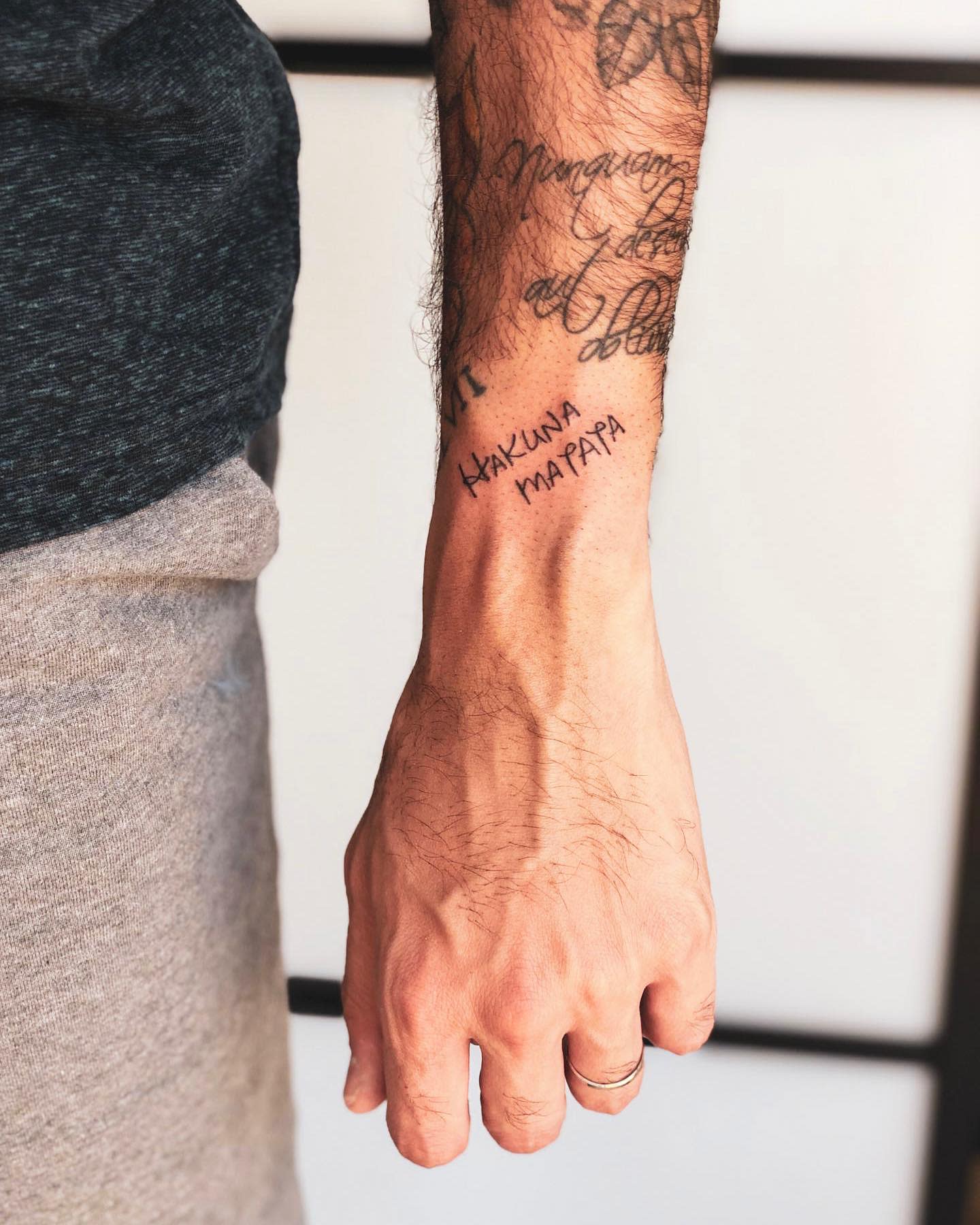 Arm with "Hakuna Matata" text tattoo